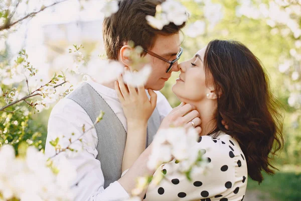 Young man and woman couple in a blooming garden — Stock Photo, Image