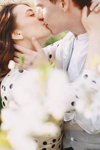 Jeune homme et femme couple dans un jardin fleuri — Photo