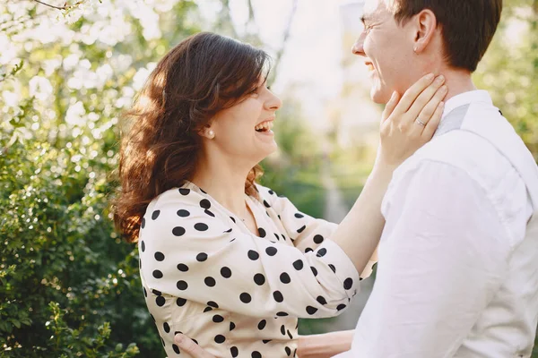 Ung man och kvinna par i en blommande trädgård — Stockfoto