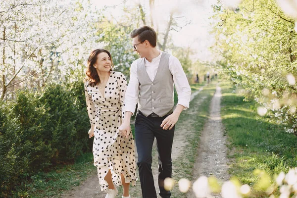 Jonge man en vrouw paar in een bloeiende tuin — Stockfoto