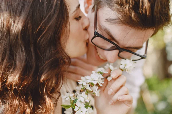 Mladý muž a žena pár v kvetoucí zahradě — Stock fotografie