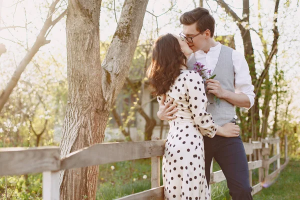 Young man and woman couple in a blooming garden — Stock Photo, Image