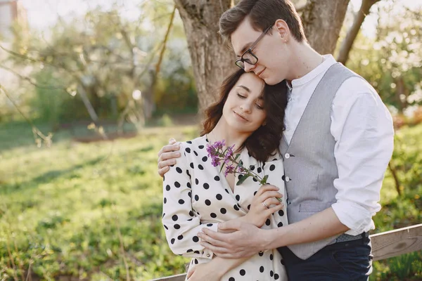 Ung man och kvinna par i en blommande trädgård — Stockfoto