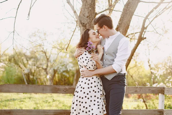 Jeune homme et femme couple dans un jardin fleuri — Photo