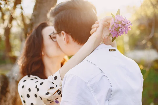 Ung man och kvinna par i en blommande trädgård — Stockfoto