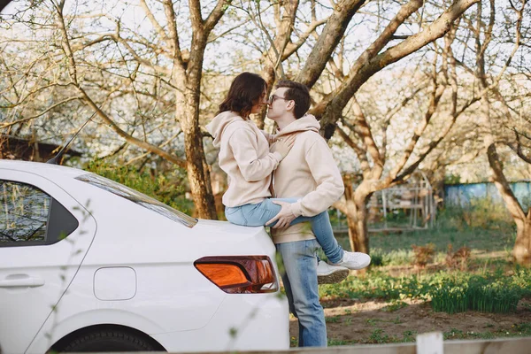 Par som sitter på en motorhuv i en park — Stockfoto