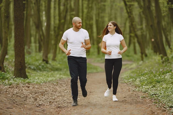 Sport couple spend time in a summer forest