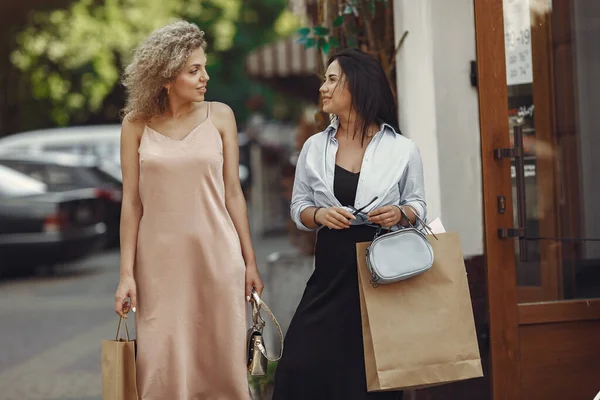 Drie elegante vrouwen met boodschappentassen in een stad — Stockfoto