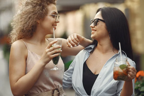 Mulheres elegantes bebem coquetéis em uma cidade de verão — Fotografia de Stock