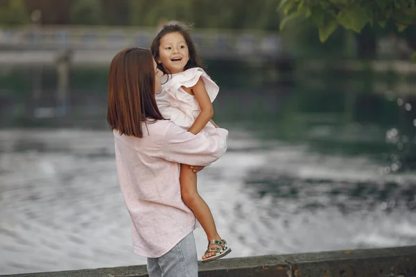 Elegant mother with daughter walks by the water — Stock Photo, Image