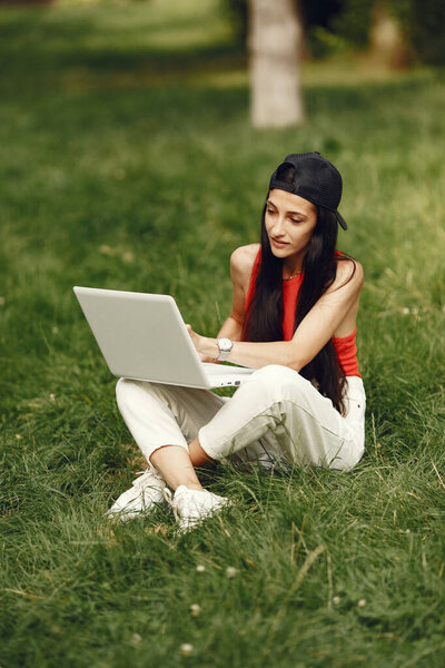 Woman in a summer park with a laptop