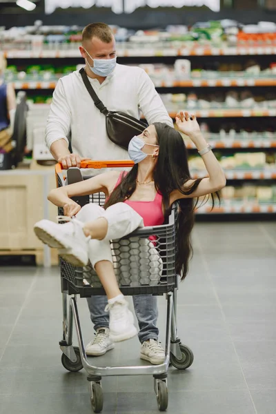 Couple in a medical masks in a supermarket