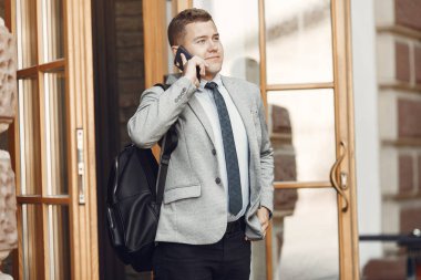 Cep telefonu olan bir şehirde duran bir iş adamı