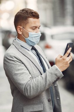 Maskeli bir iş adamı. Telefonu kullan.