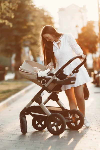 Kvinna i vit klänning med barnvagn — Stockfoto