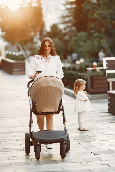 Frau im weißen Kleid mit Kinderwagen — Stockfoto