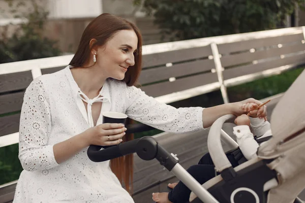 Žena v bílých šatech s kočárkem — Stock fotografie