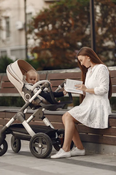 Kvinna i vit klänning med barnvagn — Stockfoto