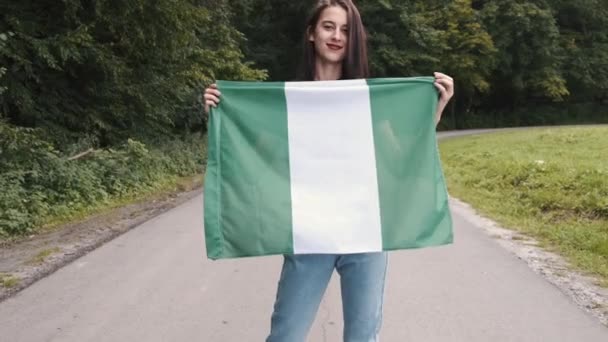 Boldog fiatal nő kezében nigériai zászló — Stock videók