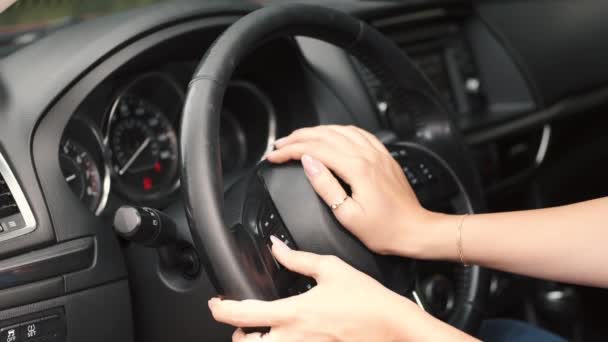Imagem cortada se as mãos femininas apitar um volante — Vídeo de Stock