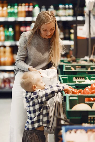 Mujer en el supermercado con su hijo — Foto de Stock