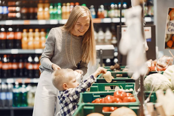 Mujer en el supermercado con su hijo — Foto de Stock