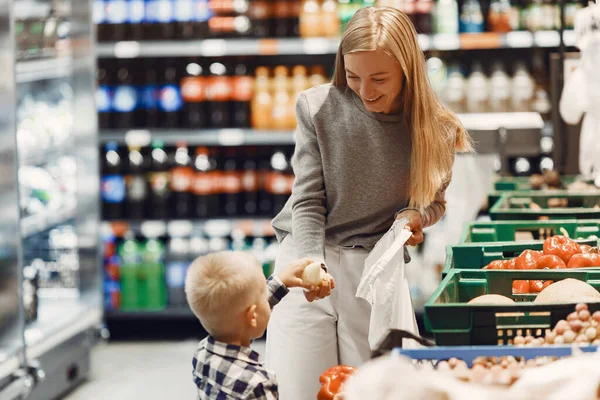 Mujer en el supermercado con su hijo — Foto de Stock