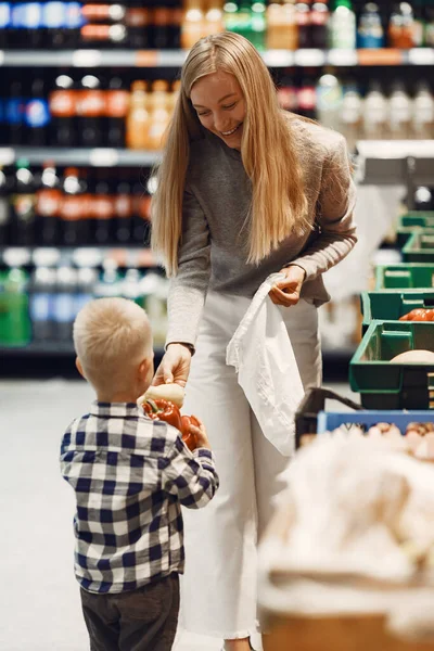 Mujer en el supermercado con su hijo — Foto de Stock