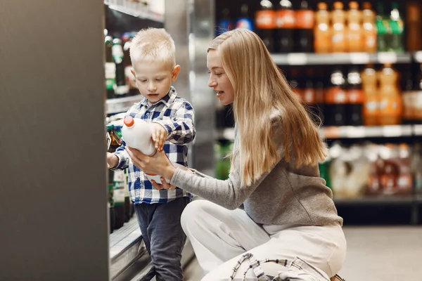 Mujer en el supermercado con su hijo — Foto de Stock