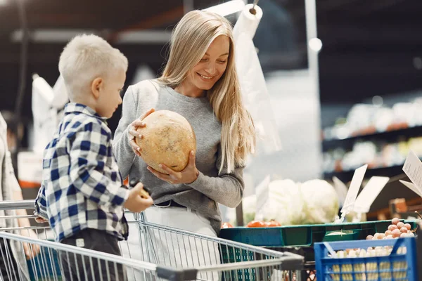 Mujer en el supermercado con su hijo — Foto de Stock
