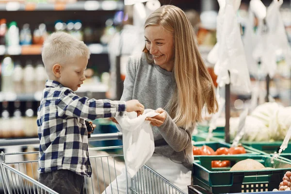 Mujer en el supermercado con su hijo — Foto de Stock