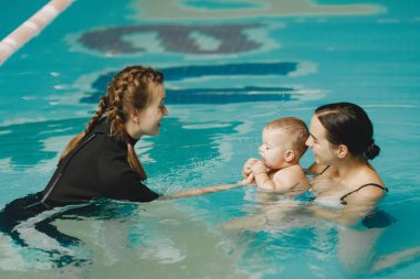 Anne ve küçük oğlu yüzme havuzunda.