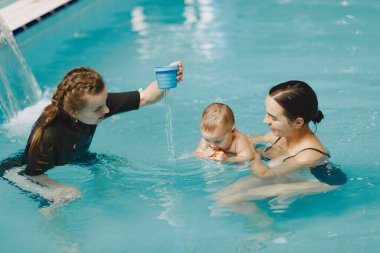 Anne ve küçük oğlu yüzme havuzunda.