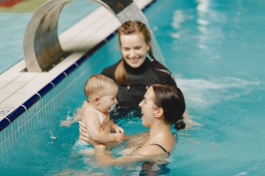 Anne ve küçük oğlu yüzme havuzunda.