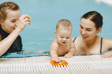 Anne ve küçük oğlu yüzme havuzunda.