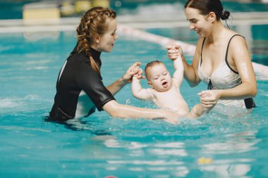 Anne ve küçük oğlu yüzme havuzunda.