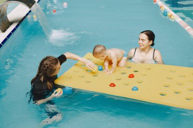 Anne ve küçük oğlu yüzme havuzunda.