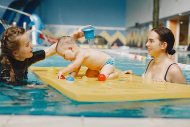 Anne ve küçük oğlu yüzme havuzunda.