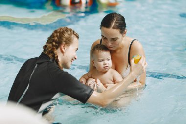 Anne ve küçük oğlu yüzme havuzunda.