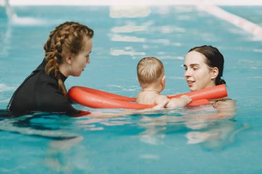 Anne ve küçük oğlu yüzme havuzunda.