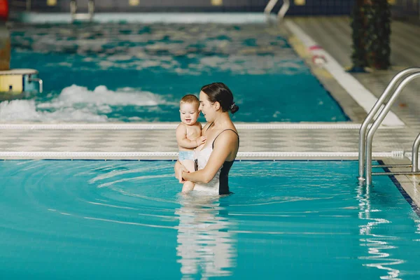 Mor och liten son njuter av att bada i en pool — Stockfoto