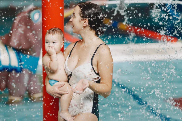 Mor och liten son njuter av att bada i en pool — Stockfoto