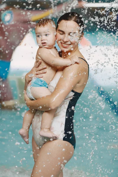 Mor och liten son njuter av att bada i en pool — Stockfoto