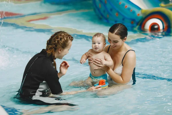 Madre e hijo pequeño en una piscina — Foto de Stock