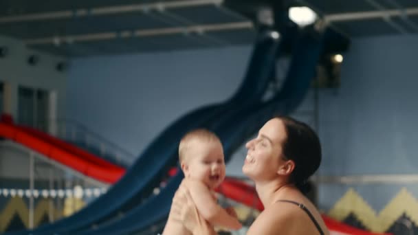 Moeder knuffelen en kussen baby kind bij het zwembad — Stockvideo
