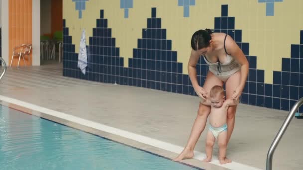 Moeder met baby zoon gaan in overdekt zwembad — Stockvideo
