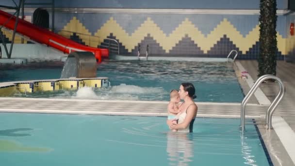 Mutter geht mit Baby-Sohn ins Hallenbad — Stockvideo