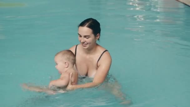 Mamá enseña a su hijo a nadar en la piscina en el parque acuático — Vídeos de Stock