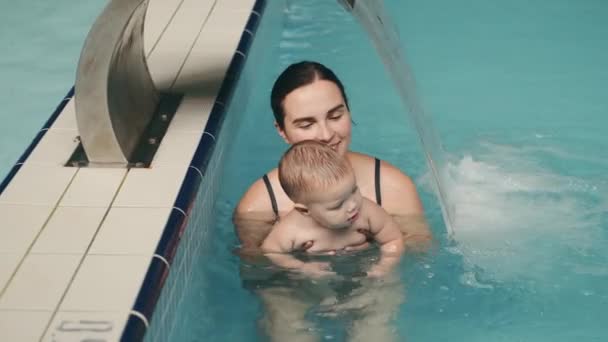 Mutter lehrt Säugling im Schwimmbad im Wasserpark schwimmen — Stockvideo