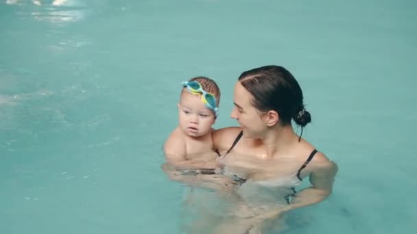 Maman enseigne aux enfants à nager dans la piscine du parc aquatique — Video